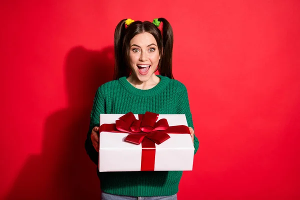 Foto de la joven hermosa sorprendida feliz chica sonriente recibir regalo de cumpleaños aislado en el fondo de color rojo —  Fotos de Stock