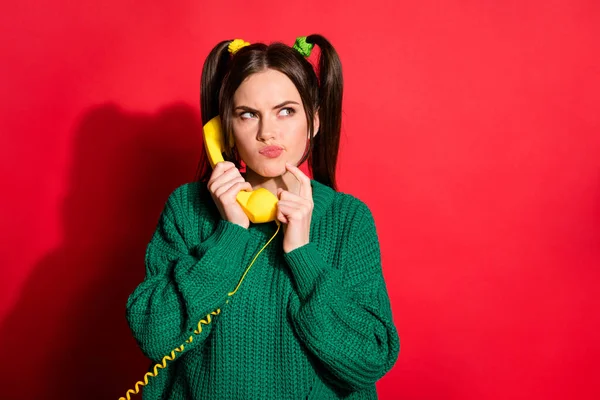 Komik, genç bir bayanın yeşil örülü kazak giyip antika telefonlar giyip boş boş boş kırmızı arka plan görüntüsü. — Stok fotoğraf