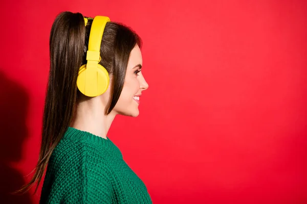 Profilseite Foto von jungen schönen lächelnd fröhlich positive Frau tragen gelbe Kopfhörer isoliert auf rotem Hintergrund — Stockfoto