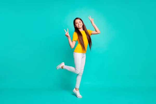 Plná velikost fotografie veselého dítěte dívka, aby v-znamení stojící izolované přes tyrkysové barvy pozadí — Stock fotografie