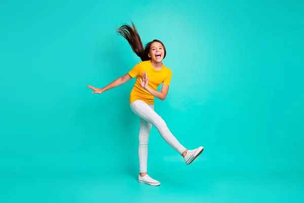 Full size foto van funky kid meisje met haar haar vliegende gevoel opgewonden verhogen been geïsoleerd over turquoise kleur achtergrond — Stockfoto