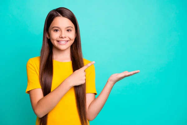 Маленька дівчинка-іспанець тримає індексну точку пальця для реклами носить жовтий одяг ізольований на кольоровому фоні — стокове фото