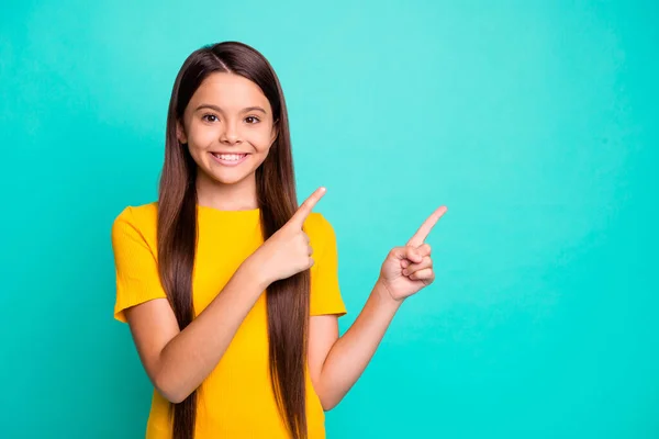 Positivo niña punta dedo índice espacio vacío para anuncios promo desgaste ropa de estilo casual aislado sobre fondo de color verde azulado —  Fotos de Stock