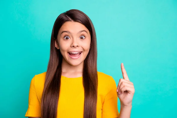 Photo of astonished small kid girl get incredible idea raise index finger wear yellow outfit isolated over teal color background — Stock Photo, Image