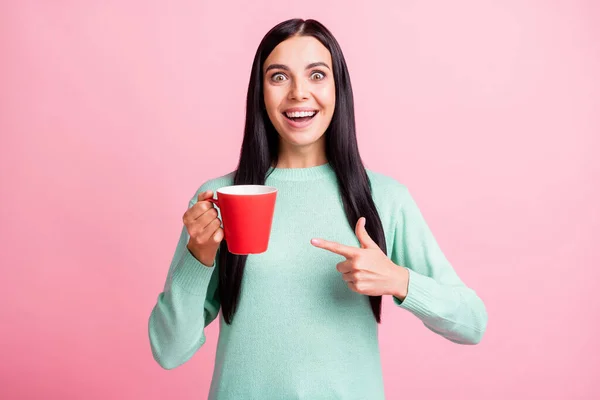 Foto ritratto di donna scioccata puntando il dito verso la tazza rossa in una mano isolato su sfondo rosa pastello — Foto Stock