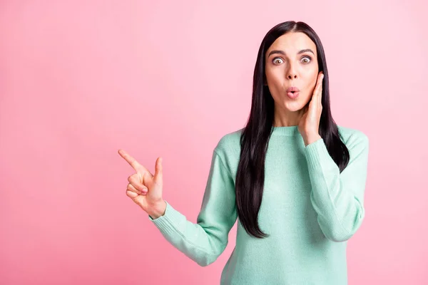 Foto ritratto di donna scioccata puntando il dito verso lo spazio vuoto toccare faccia guancia con mano isolata su sfondo rosa pastello — Foto Stock