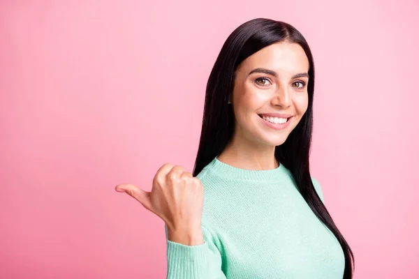 Foto ritratto di ragazza che punta il pollice a spazio vuoto dietro la schiena isolato su sfondo rosa pastello — Foto Stock