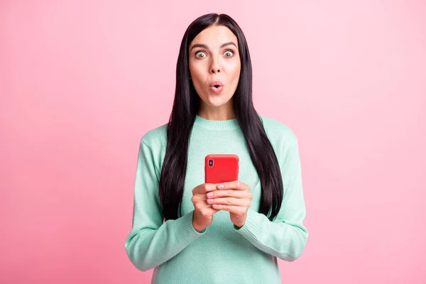 Foto retrato de mulher chocada segurando telefone com duas mãos isoladas no fundo de cor rosa pastel — Fotografia de Stock