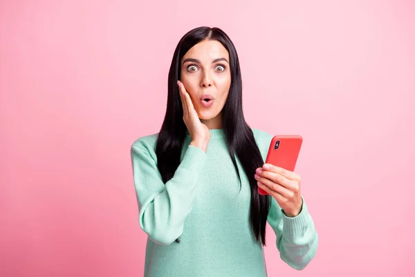 Fényképezés portré sokkos lány megható arc arc tartó telefon az egyik kezében elszigetelt pasztell rózsaszín színű háttér — Stock Fotó
