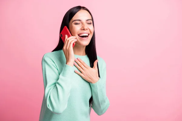 Фотопортрет смеющейся девушки, говорящей по телефону на розовом фоне — стоковое фото