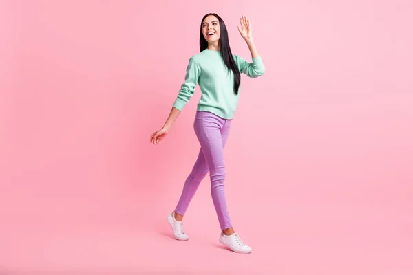 Foto de longitud completa de amable linda mujer joven vestida de color turquesa suéter agitando brazo aislado de color rosa de fondo —  Fotos de Stock