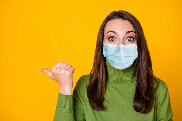 Close-up portret van verbaasd meisje demonstreren lege ruimte dragen blauw gezicht masker geïsoleerd over helder gele kleur achtergrond — Stockfoto