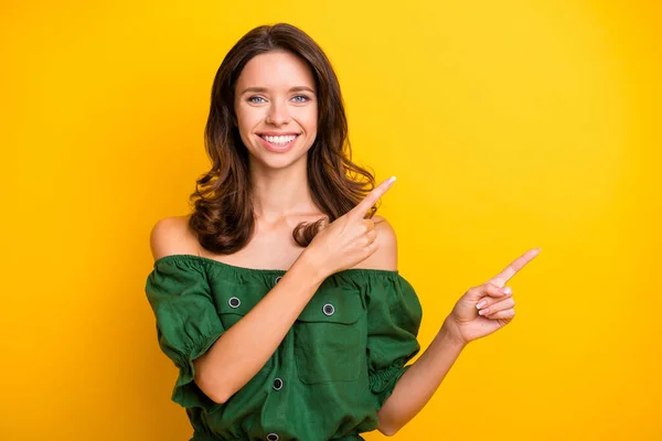 Foto di affascinante bella donna positiva punta il dito vuoto promozione spazio isolato su lucentezza colore giallo sfondo — Foto Stock