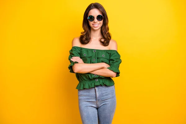 Foto de confianza feliz agradable mujer joven doblado manos usar gafas de sol aislado en el brillo de color amarillo de fondo — Foto de Stock