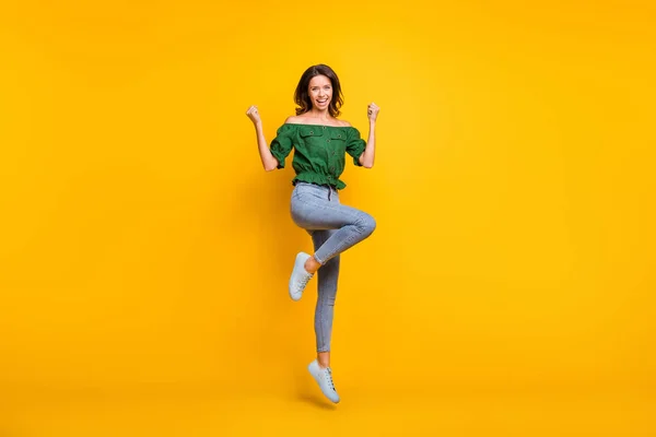 Pełne ciało zdjęcie zwycięskiej szczęśliwej kobiety podnieść pięści tak skakać nosić buty izolowane na połysk żółty kolor tła — Zdjęcie stockowe
