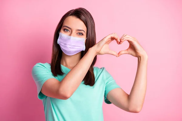Foto portret van vriendin handen in hartvorm in teal t-shirt respirator geïsoleerd op pastel roze kleur achtergrond — Stockfoto