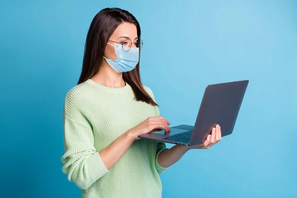 Foto van slimme meisje zoeken statistieken op laptop dragen blauw gezicht masker geïsoleerd over blauwe kleur achtergrond — Stockfoto