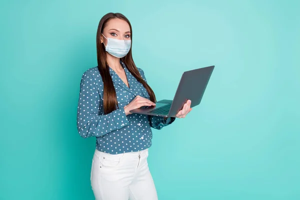 Φωτογραφία του θετικού παράγοντα κορίτσι εργασίας laptop φορούν πουά ρούχα φορούν μάσκα απομονώνονται σε τυρκουάζ χρώμα φόντο — Φωτογραφία Αρχείου