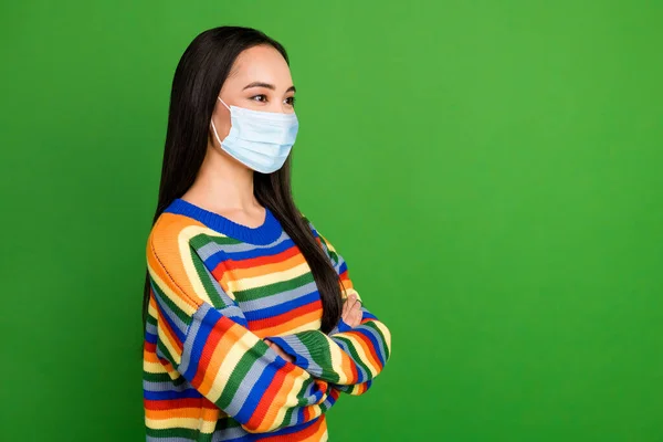 Profiel foto van aantrekkelijk meisje gevouwen armen dragen gezicht medisch masker geïsoleerd over helder groene kleur achtergrond — Stockfoto