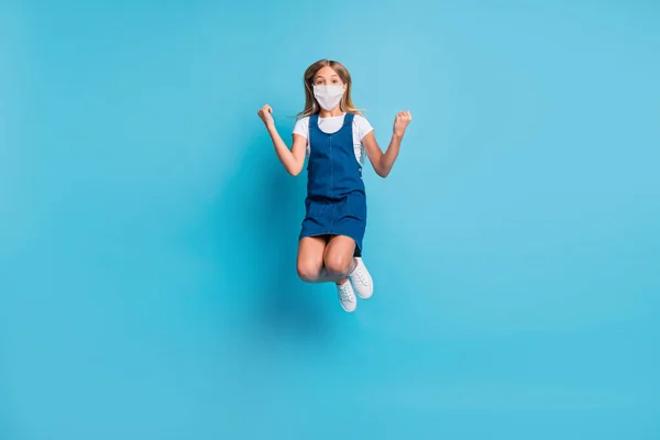 Full size foto van hooray meisje springen dragen gezichtsmasker t-shirt jurk schoenen geïsoleerd op pastel blauwe kleur achtergrond — Stockfoto