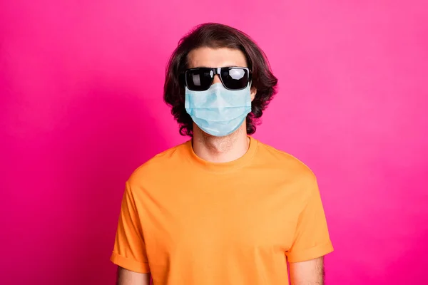 若い男の写真は、カメラは、医療用マスクオレンジTシャツサングラス孤立ピンク色の背景を身に着けている — ストック写真