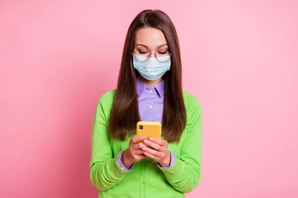 Retrato de menina em máscara respiratória usar celular rede social corona vírus notícias isolado fundo cor pastel — Fotografia de Stock