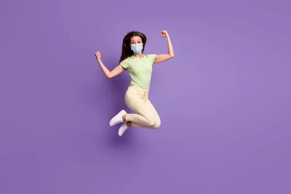Visão de comprimento total de menina saltando tendo máscara de desgaste isolado brilhante brilhante brilho vibrante cor lilás violeta fundo — Fotografia de Stock
