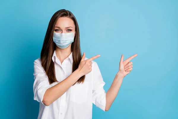 Foto van mooie dame goed humeur directe vingers kant lege ruimte slijtage masker wit shirt geïsoleerde blauwe kleur achtergrond — Stockfoto