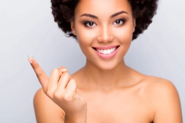 Nahaufnahme Foto von fröhlichen afroamerikanischen Mädchen besuchen Optiker empfehlen Kontaktlinse halten Zeigefinger isoliert über grauem Hintergrund — Stockfoto