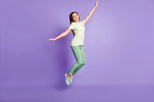 Pleine photo du corps de charmante personne sauter bras volant porter tenue vert clair isolé sur fond de couleur violette — Photo