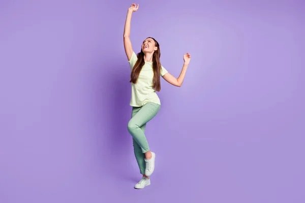 Фотографія красивої людини, яка насолоджується танцювальним носінням світло-зеленого одягу ізольовано на фіолетовому кольоровому фоні — стокове фото