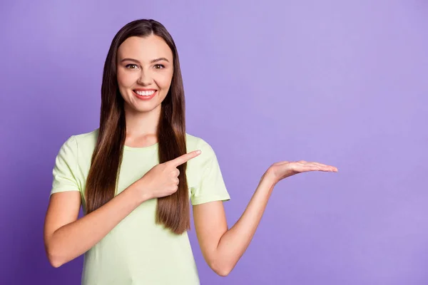 Foto van aantrekkelijke persoon arm houden product directe vinger lege ruimte slijtage licht groen geïsoleerd op violette kleur achtergrond — Stockfoto