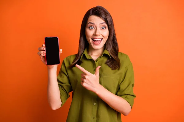 Portrait photo de brune joyeuse montrant à l'écran vide téléphone portable souriant isolé sur fond de couleur orange vif — Photo