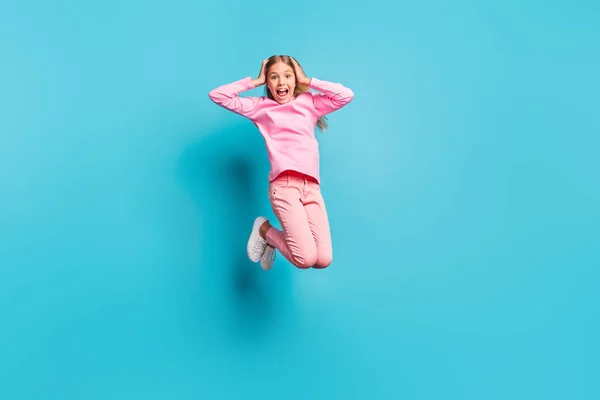 Full size foto van cool verrast mooi tiener meisje springen lucht handen hoofd schreeuwen dragen roze broek poloneck wit schoeisel geïsoleerd op teal achtergrond — Stockfoto