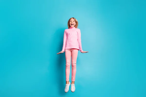 Πλήρης φωτογραφία μέγεθος του δροσερό έκπληκτος ωραίο έφηβος κορίτσι άλμα αέρα φορούν ροζ παντελόνι poloneck λευκά υποδήματα που απομονώνονται σε teal φόντο — Φωτογραφία Αρχείου