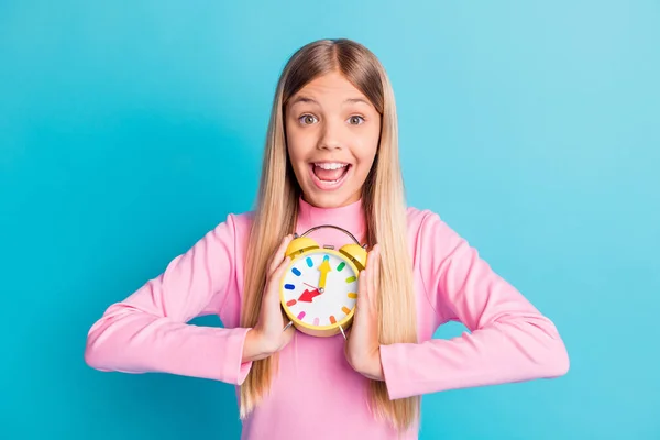 Retrato fotográfico de una alegre chica excitada manteniendo colorida la alarma con la boca abierta aislada sobre un vibrante fondo de color turquesa — Foto de Stock