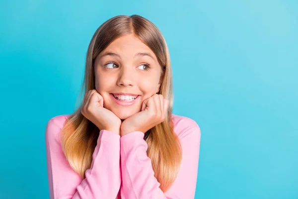 Fotoporträt von verträumten Schulmädchen mit blonden Haaren, die lächelnd Wangenknochen berühren, mit isolierten Händen auf lebendigem türkisfarbenem Hintergrund — Stockfoto