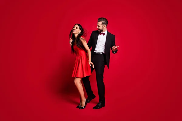 Photo de profil pleine grandeur de couple optimiste tenue de danse robe vive costume noir isolé sur fond de couleur rouge — Photo