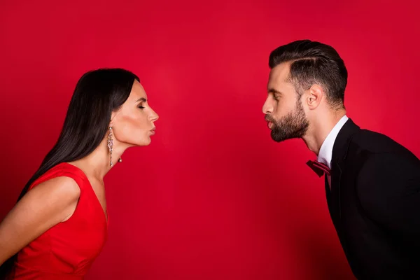 Photo of charming lady neat guy closing distance kiss lips closed eyes isolated on red color background