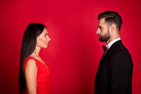 Foto de perfil de buena pareja se ven el uno al otro usan traje vestido aislado sobre fondo de color rojo — Foto de Stock