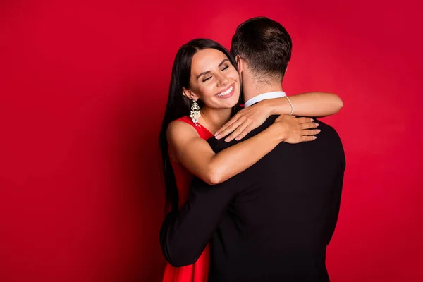 Φωτογραφία του αισιόδοξου ωραίο ζευγάρι αγκαλιά χορό φορούν κοστούμι φόρεμα απομονώνονται σε φόντο κόκκινο χρώμα — Φωτογραφία Αρχείου