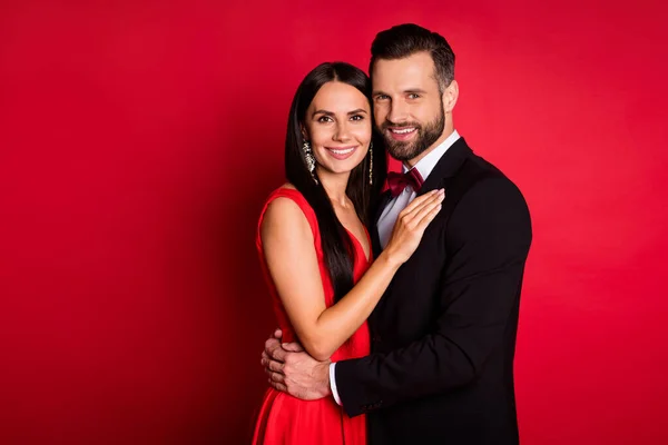 Foto de perfil de optimista linda pareja abrazo look traje vestido aislado sobre fondo de color rojo —  Fotos de Stock