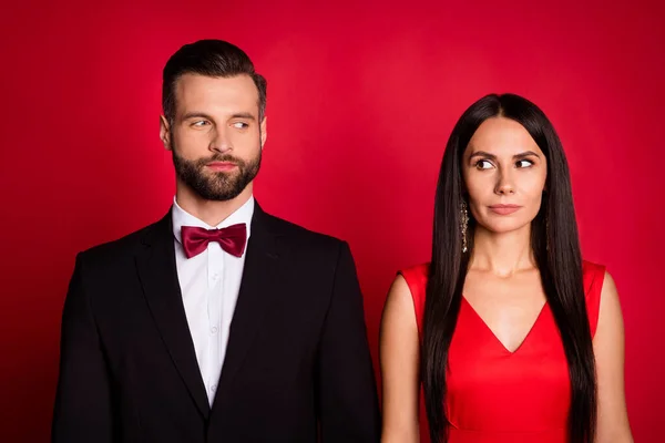 Retrato de pareja bonita se miran el uno al otro usan traje vestido aislado sobre fondo de color rojo — Foto de Stock