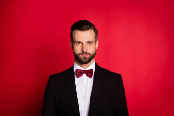 Retrato de hombre guapo llevar traje negro aislado sobre fondo de color rojo — Foto de Stock