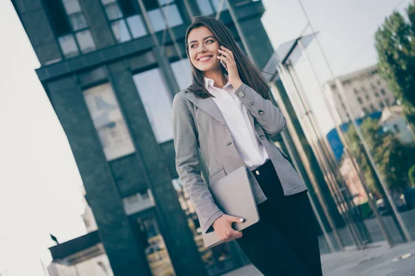 Foto av charmig affärskvinna prata telefon håll dator slitage formalwear jacka byxor utomhus — Stockfoto