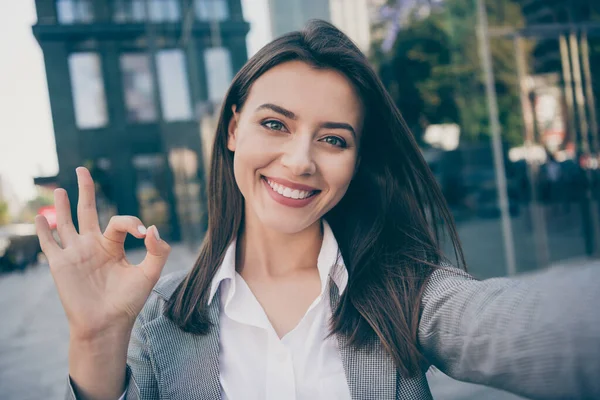 Zdjęcie optymistyczne ładna bizneswoman nosić formalwear kurtka zrobić selfie zrobić dobrze znak na zewnątrz w plenerze — Zdjęcie stockowe