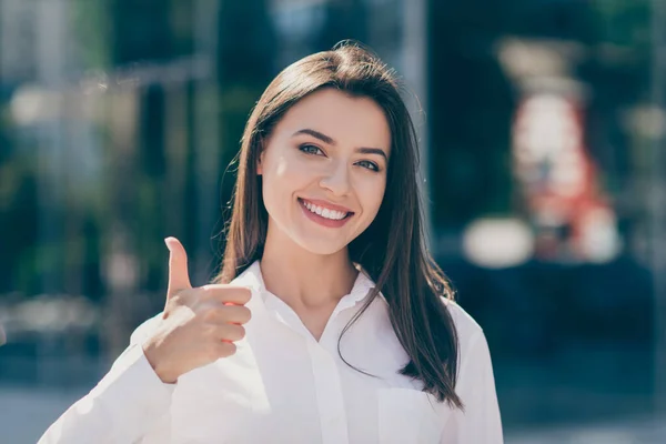 Photo de douce charmante jeune femme habillée chemise formelle blanche souriante montrant pouce vers le haut à l'extérieur — Photo