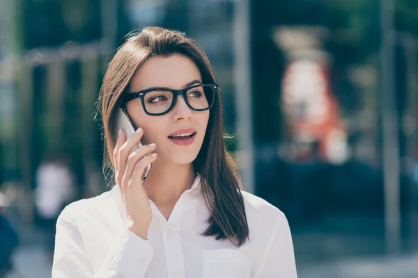 Fénykép fényes édes fiatal nő visel fehér formális ing szemüveg beszél modern eszköz látszó oldalán szabadban — Stock Fotó