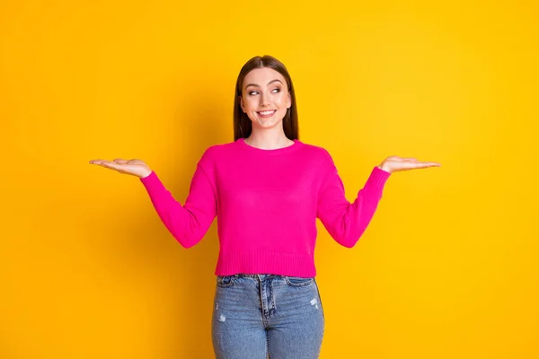 Foto da menina encantadora de dois braços olhar vazio espaço brilhante sorriso desgaste rosa camisola jeans isolado cor amarela fundo — Fotografia de Stock