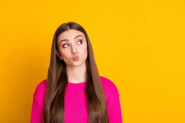 Фото красивої дівчини смішні губи похмурість дивитися вгору порожній простір відправити повітряний поцілунок носити рожевий светр ізольований жовтий колір фону — стокове фото